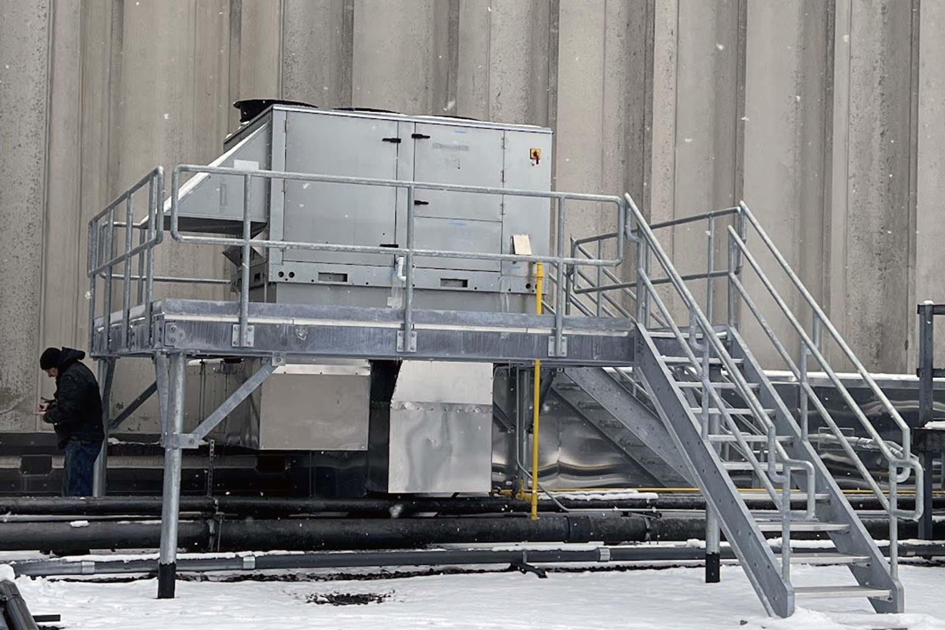 outdoor metal stairs and landing with large HVAC unit