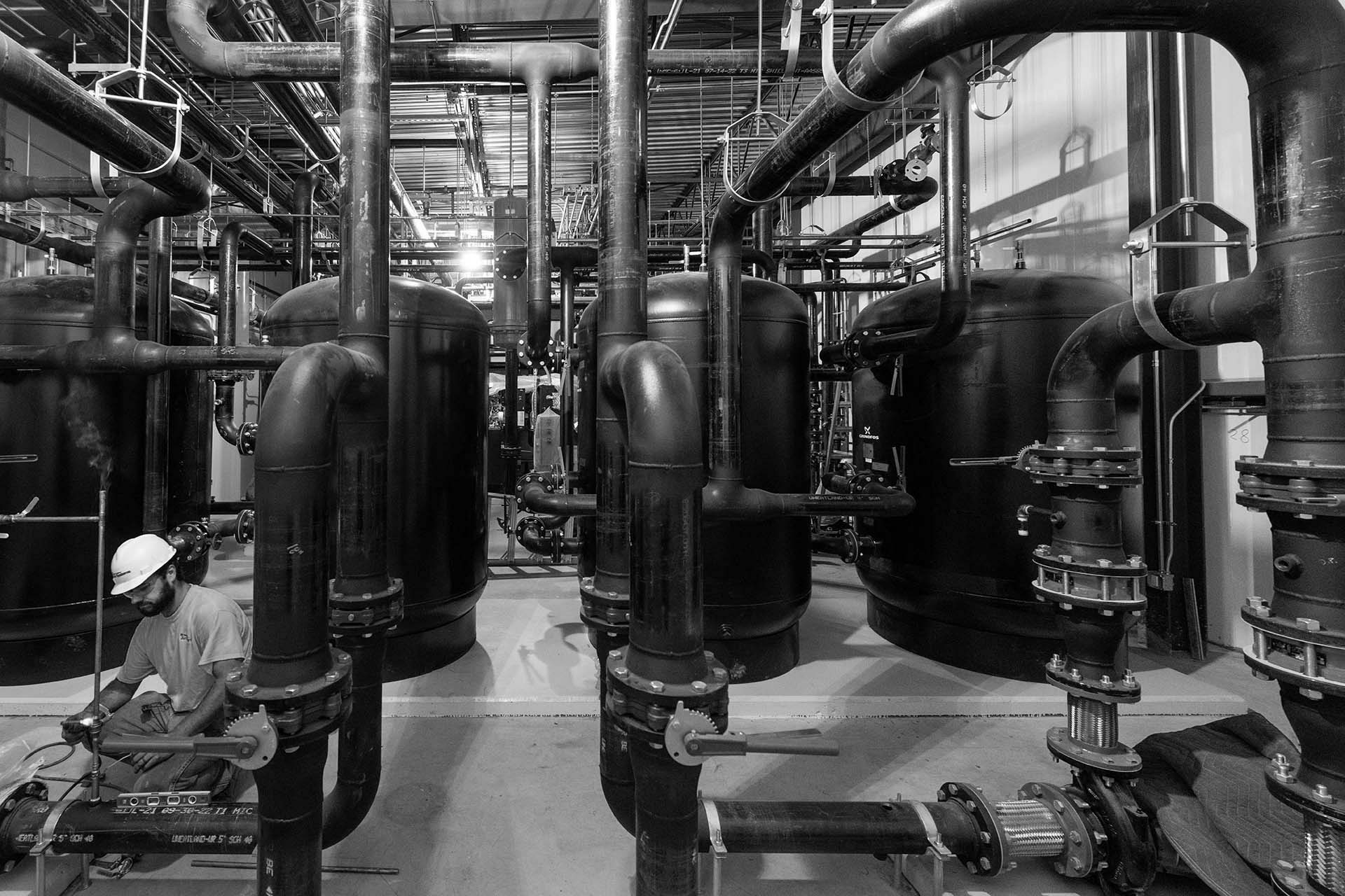 NE air employee working in large mechanical system room