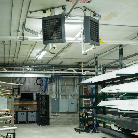 room filled with rowing boats and air ventilation system fans