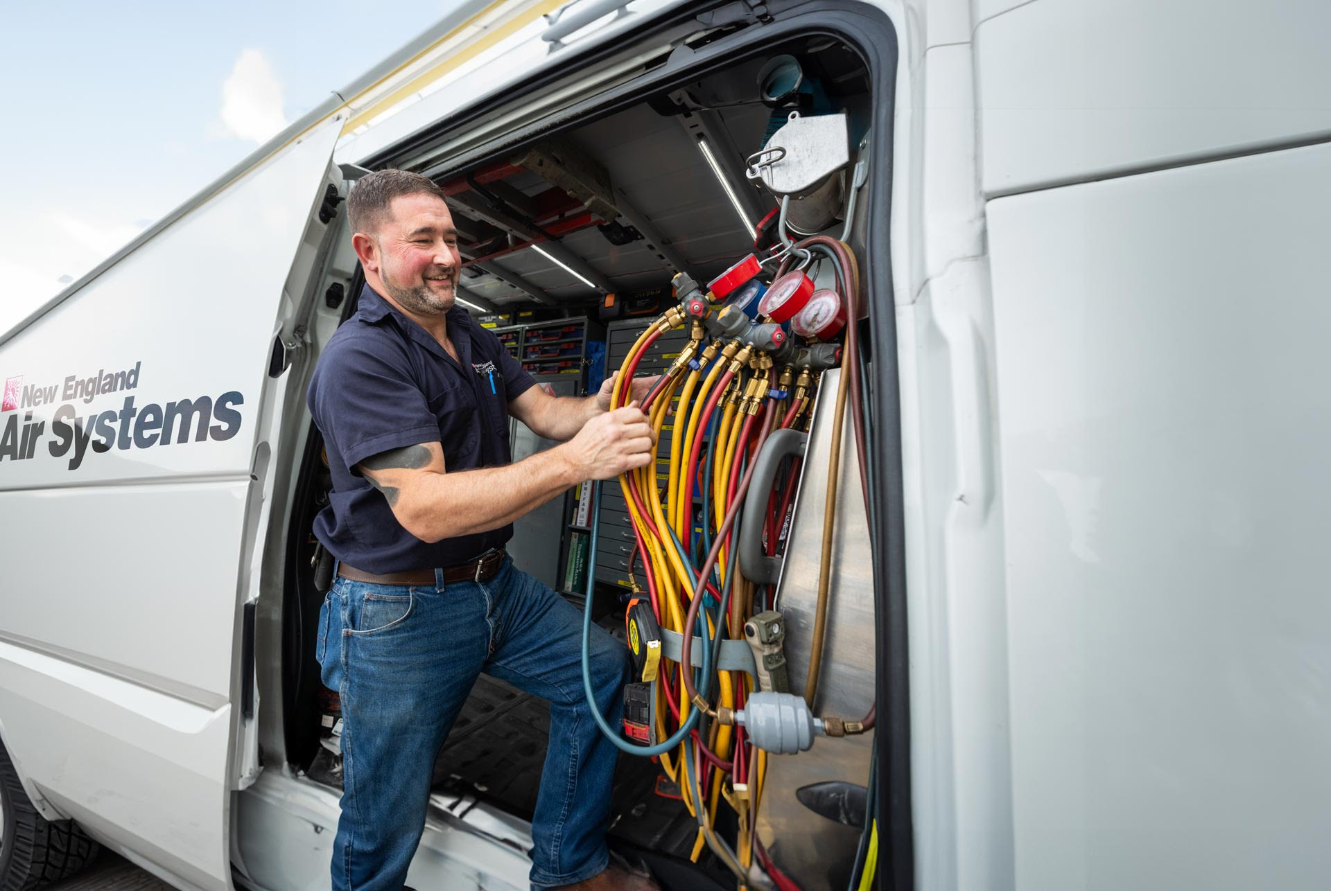 NE Air employee smiling while working in service van