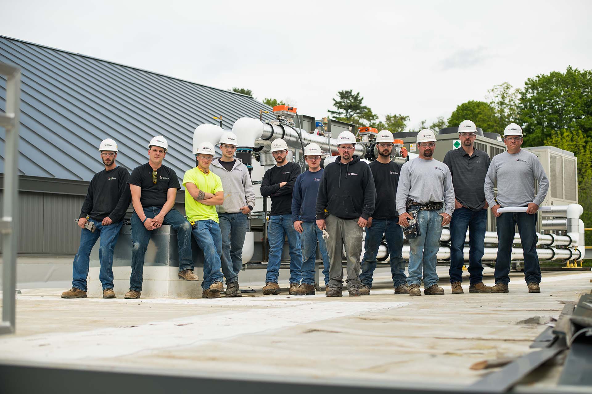 group of NE employees wearing hardhats on a rooftop